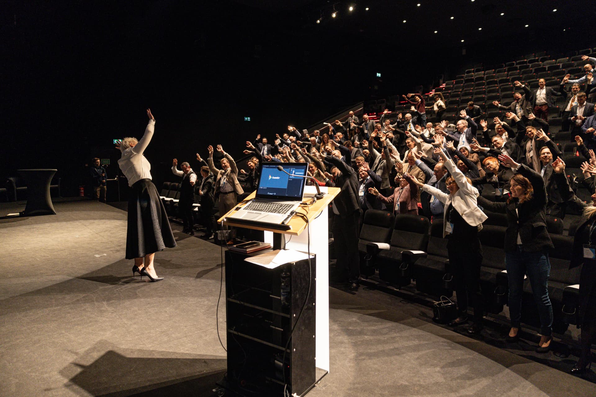Brigitta Hoeferle, host of Asentiv Atlanta, on stage with the Asentiv community